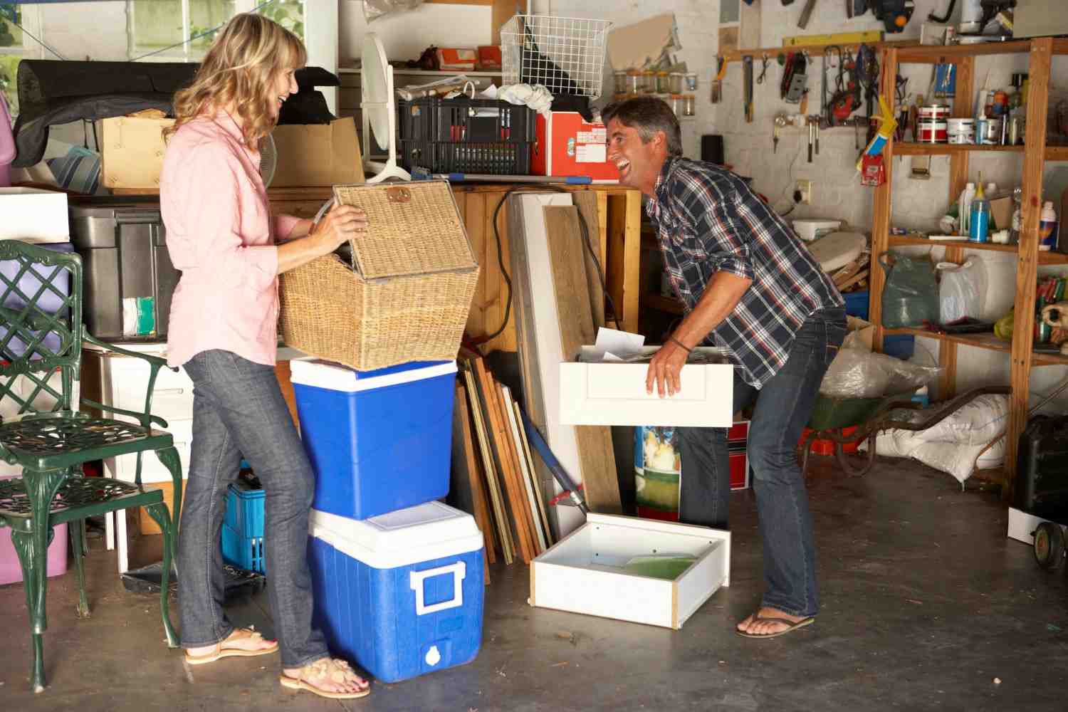 Garage cleanout project with homeowners sorting storage bins and household junk in Acworth, GA
