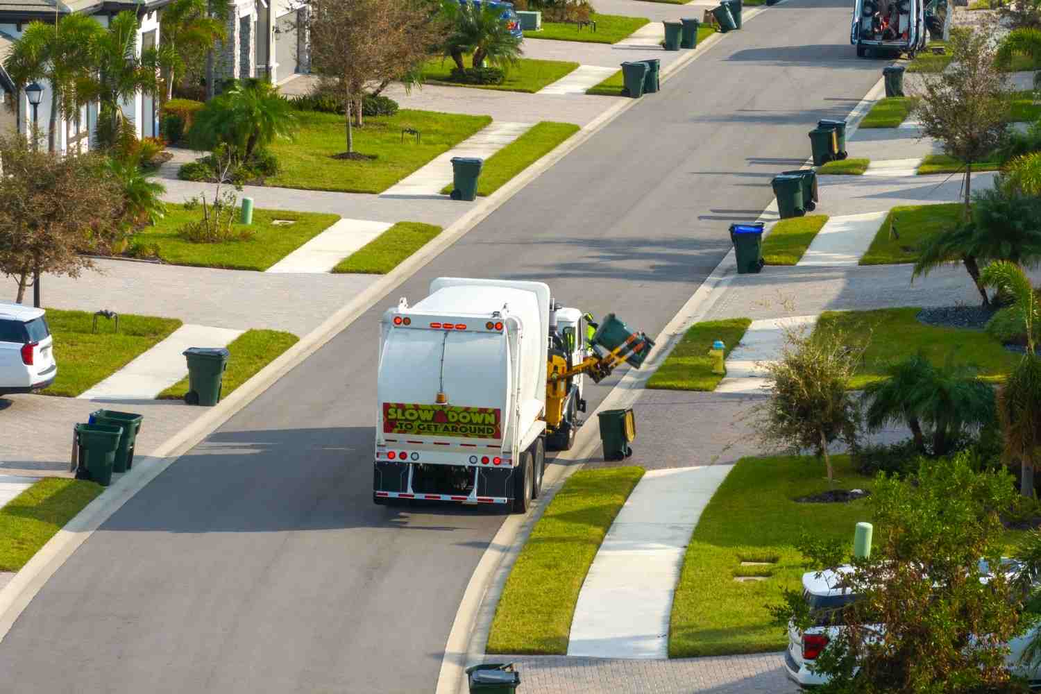 Residential trash truck collecting curbside waste bins in a neighborhood in Acworth, GA